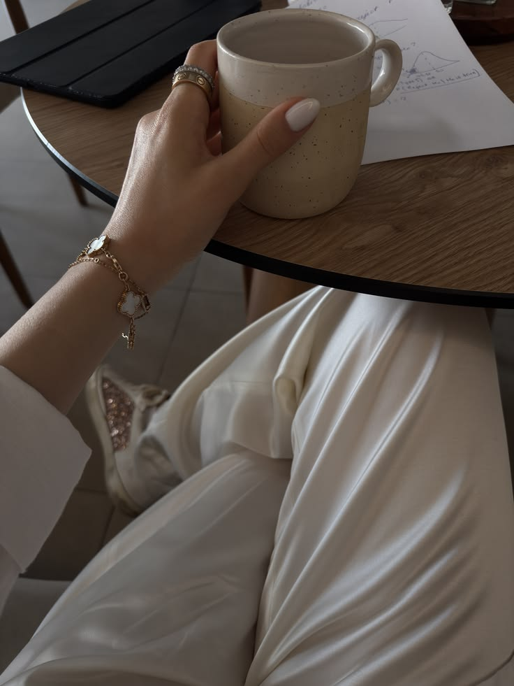 Mão segurando uma xícara de cappuccino em um momento de cuidado e acolhimento